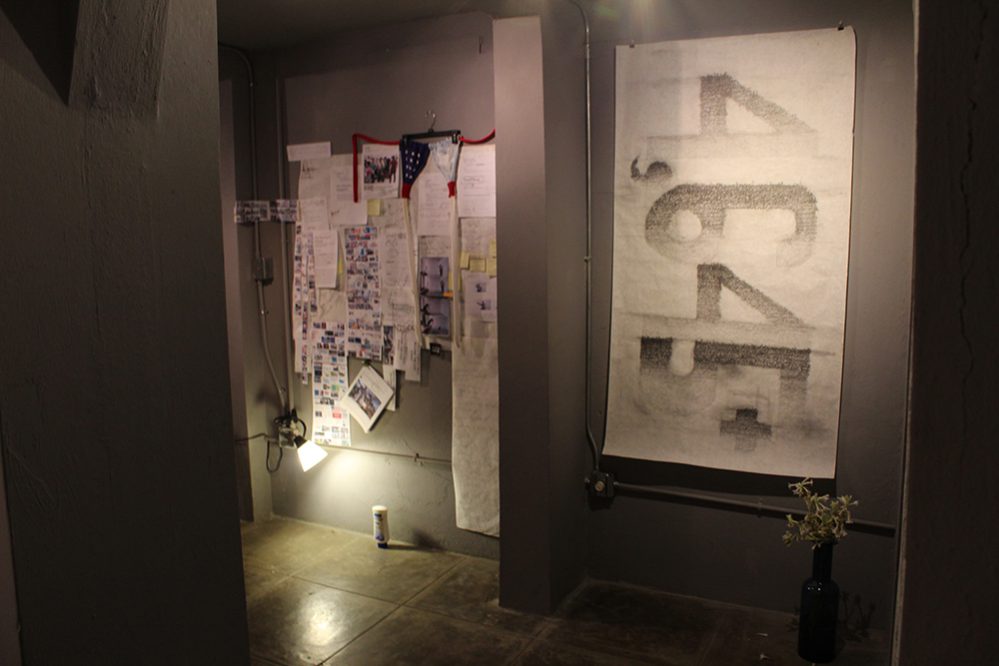 Vista de sala con la instalación "Script", 2017, papel, grafito, bolígrafo, plástico, retazos de papel, fotocopias a color y tela, 56” x 55” y "Flags" (bikini), 2017, tela, plastico, metal, 14” x 41” de la artista Lilliam Nieves.